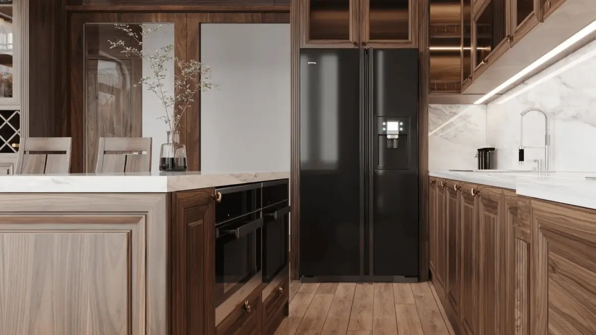 Cận cảnh khu bếp – tủ lạnh side-by-side màu đen tích hợp vào hệ tủ bếp gỗ óc chó cổ điển, mặt bàn đá trắng, ốp lưng marble sang trọng