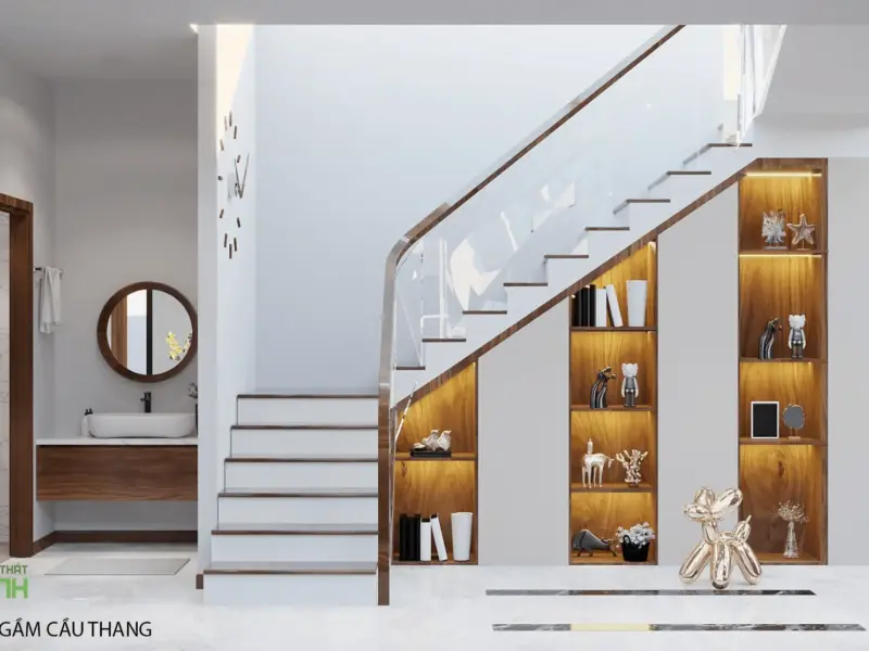 Cầu thang kinh trắng – tủ trang trí gầm cầu thang đèn LED vàng trưng bày tượng, lavabo thoáng bên cạnh có gương tròn gỗ