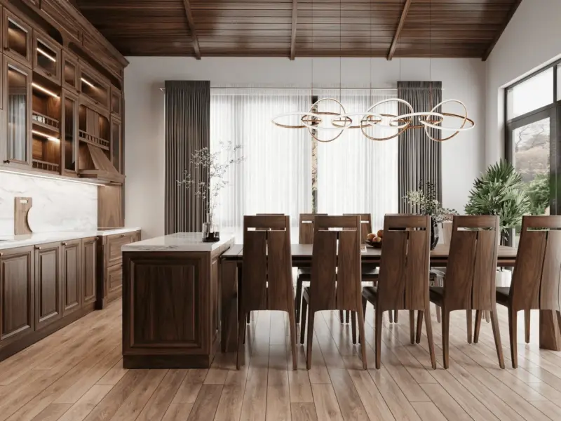 Góc nhìn thứ 2 phòng ăn – bếp: đảo bếp mặt đá trắng làm trọng tâm, tủ bếp gỗ óc chó kiểu cổ điển có kính, mái vòm nhọn tạo chiều cao ấn tượng